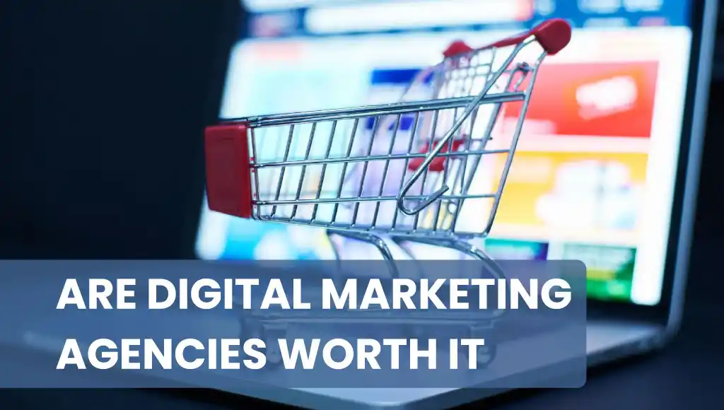 A miniature shopping cart on a laptop screen with colorful digital visuals, representing the question: are digital marketing agencies worth it for businesses.